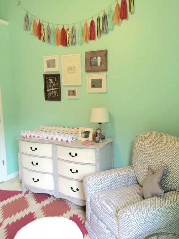 Our comfy glider and fabulous antique dresser turned changing table.  Kat helped me hang some  frames and tassel garland today, and I'm so happy with how it turned out!